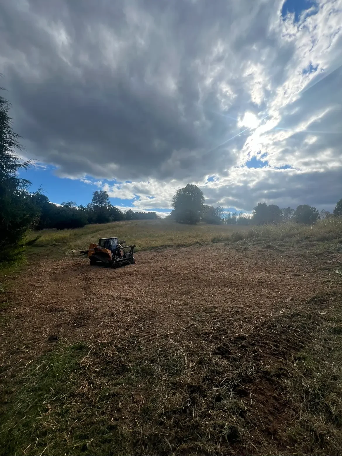 Tracked forestry mulcher on a freshly mulched field after clearing overgrowth.