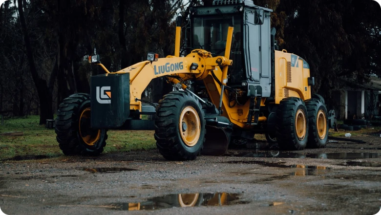 Motor grader parked on a gravel site, ready for grading and site preparation.